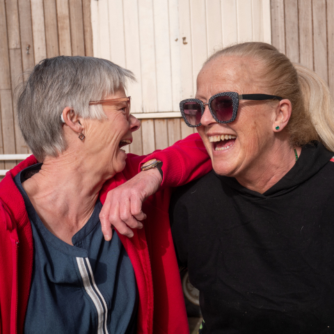 Trois bénévoles souriants et transportant des dons